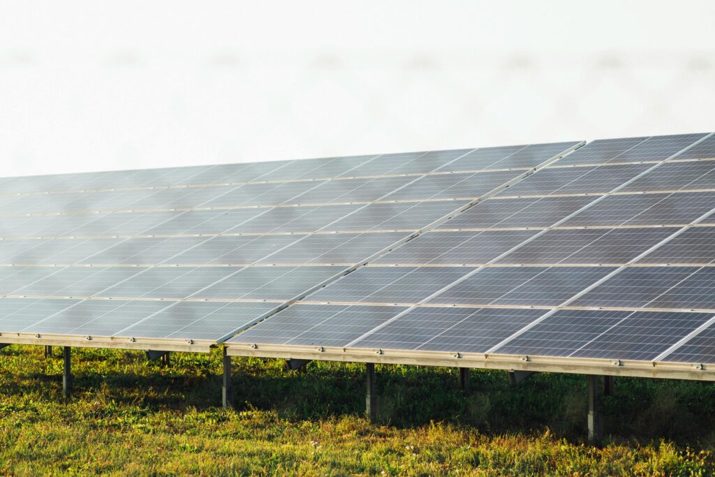 Expansive solar panel array harnessing clean energy in a sunny outdoor field scene.